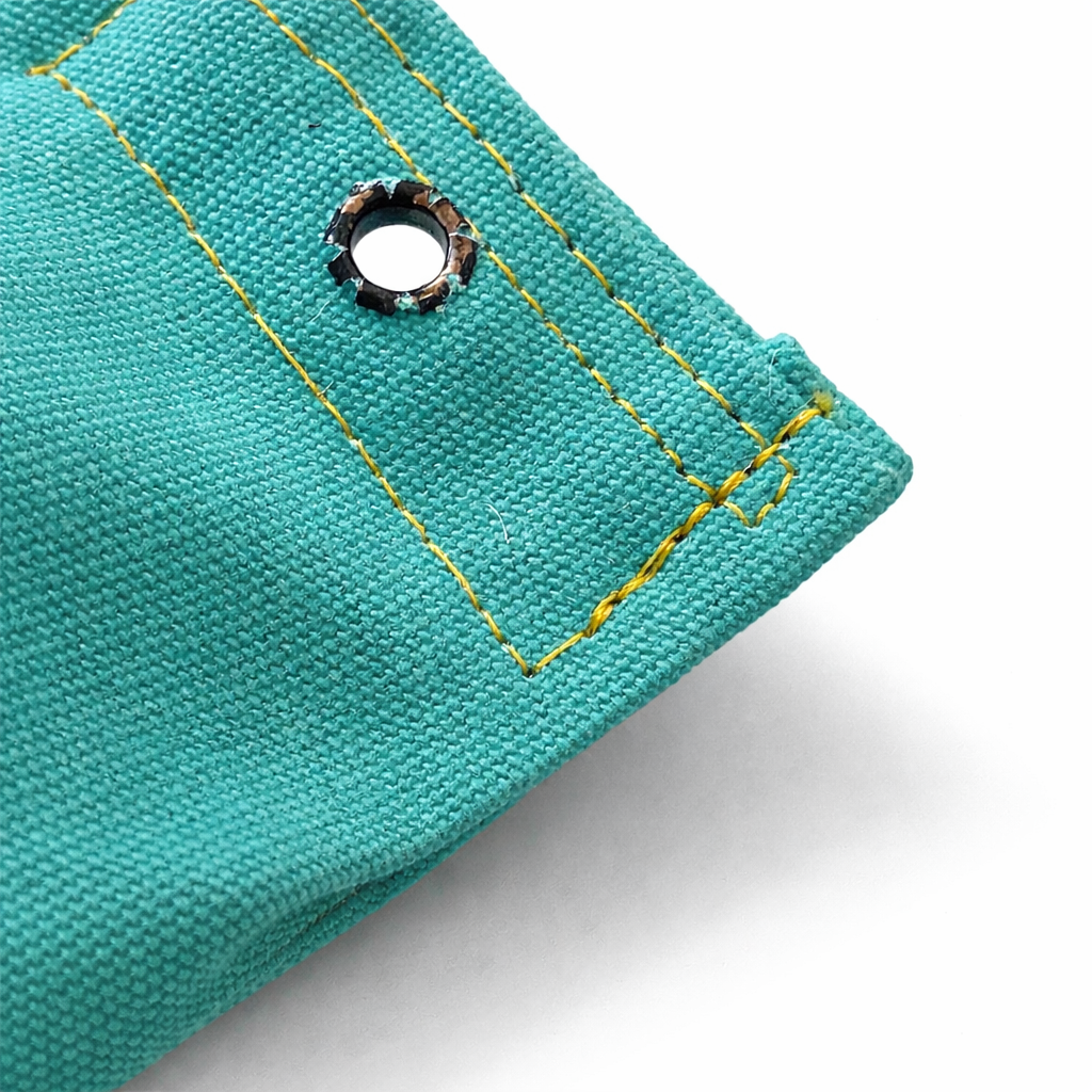 Close-up of teal dog dummy stitching on a white background