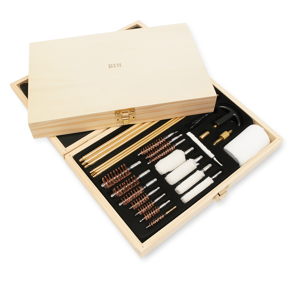 Wooden gun cleaning kit with various tools inside an open wooden box on a white background.