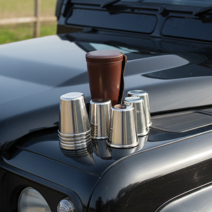 Set of metal cups and a brown case on a car hood