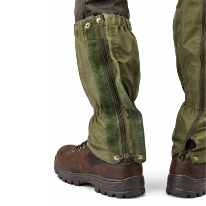 Green gaiters worn over brown boots on a white background