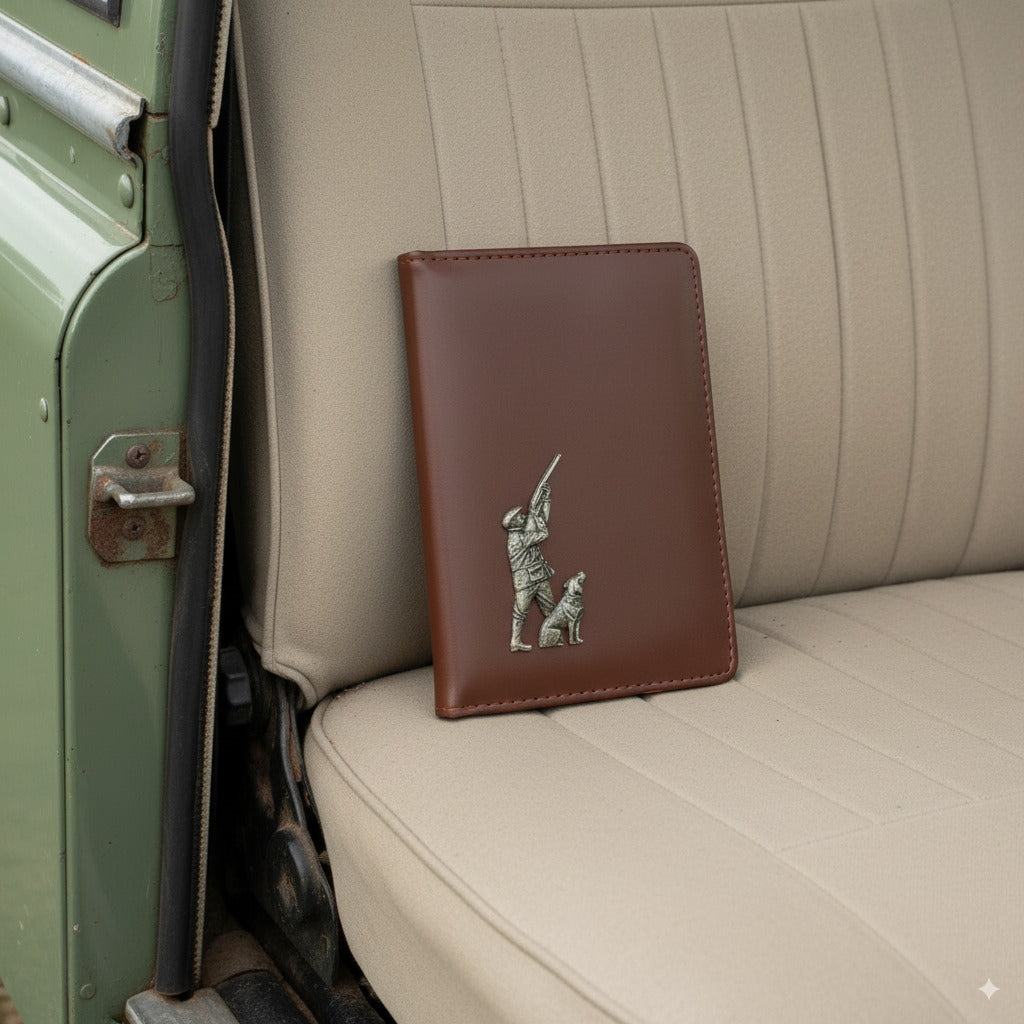 Brown leather wallet with a hunting design on a car seat