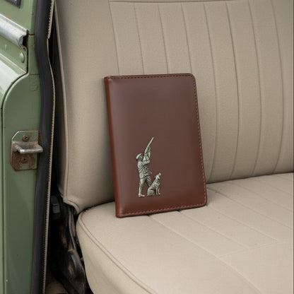 Brown leather wallet with a hunting design on a car seat