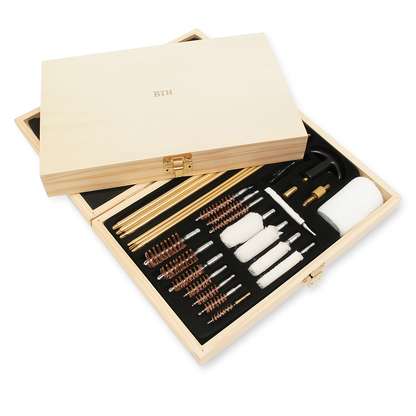 Wooden gun cleaning kit with various tools inside an open wooden box on a white background.