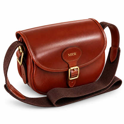 A brown leather cartridge bag with a matching fabric shoulder strap, featuring a gold buckle and a personalized 'MRW' monogram on the front flap, set against a plain white background.