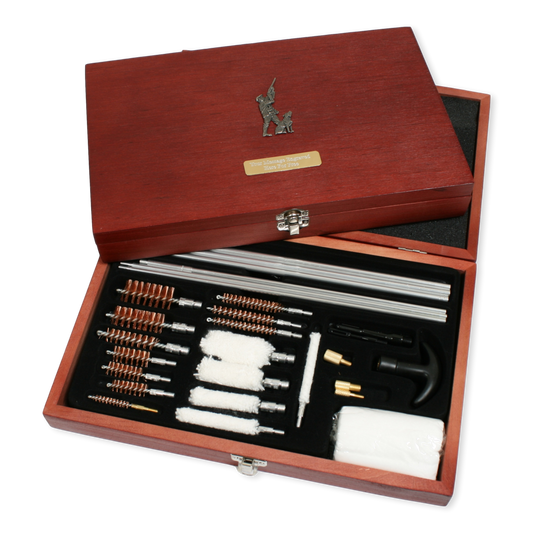 Wooden gun gun cleaning kit with various tools inside an open box on a white background