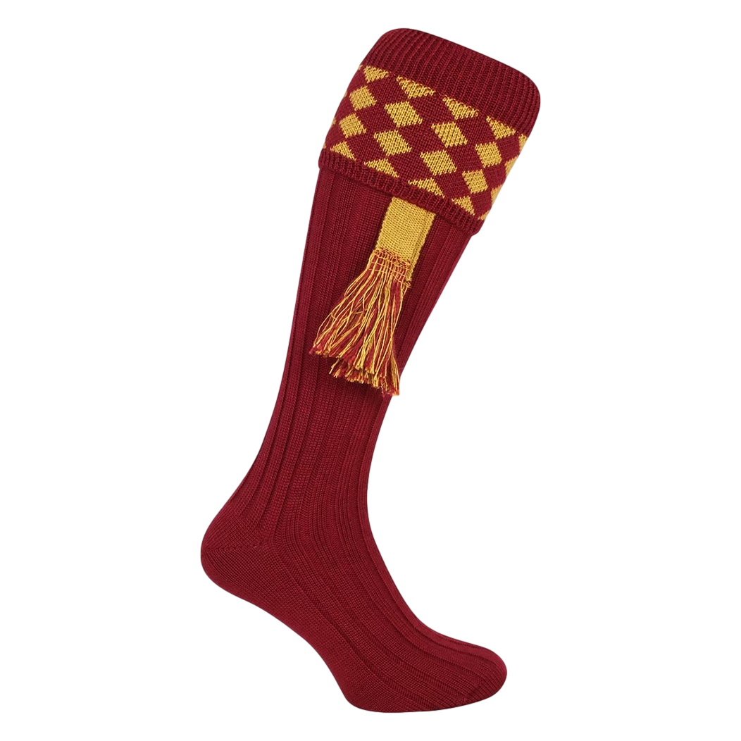 Red knee-high sock with yellow diamond pattern and tassel on a white background