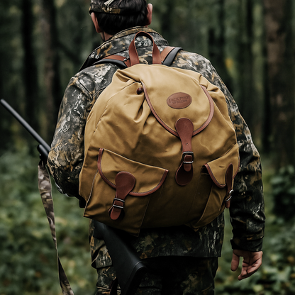 Person in camouflage clothing with a tan backpack walking through a forest.