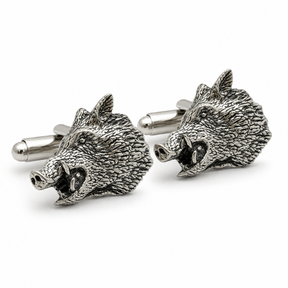 A pair of pewter metal cufflinks shaped like the heads of wild boars, shown on a clean white background.