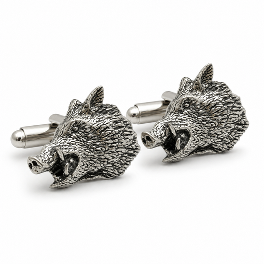 A pair of pewter metal cufflinks shaped like the heads of wild boars, shown on a clean white background.