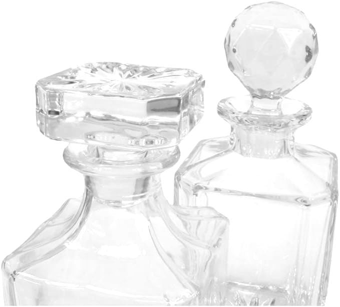 two glass decanters with different stopper styles on white background