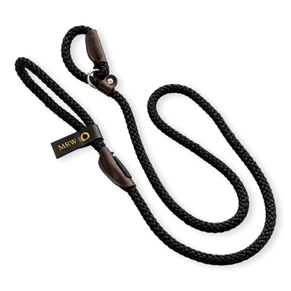 Black dog leash with brown leather ends and a visible embossing tag on a white background