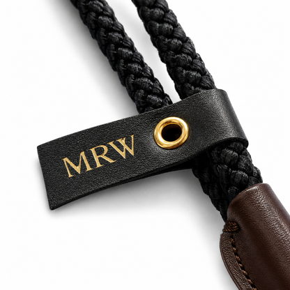 Black braided dog lead with a leather tag embossed with 'MRW' on a white background