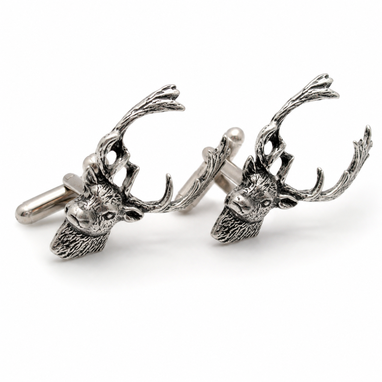 A pair of pewter cufflinks shaped like fallow deer heads with detailed antlers, shown on a clean white background.