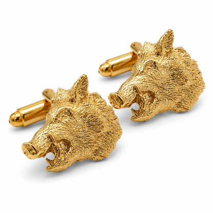 A pair of gold plated cufflinks shaped like detailed wild boar heads, shown on a clean white background.