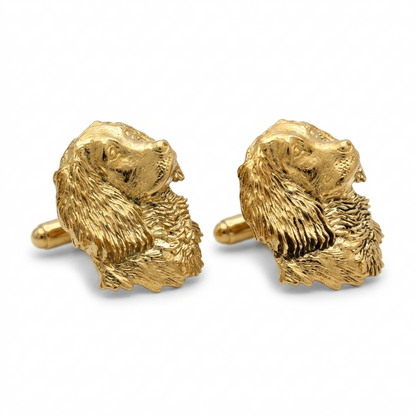 A pair of gold plated cufflinks shaped like spaniels, shown on a clean white background.