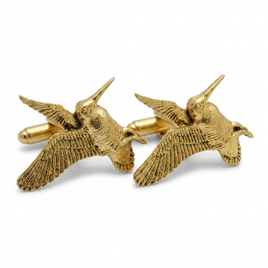 A pair of gold plated cufflinks shaped like flying woodcocks, shown on a clean white background.