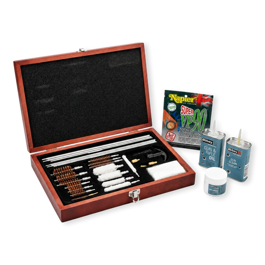 A wooden gun cleaning box filled with multiple metal cleaning or repair tools, shown open on a white studio background. Several small gun cleaning products and a Napier Super VP90 packet are placed beside the box.