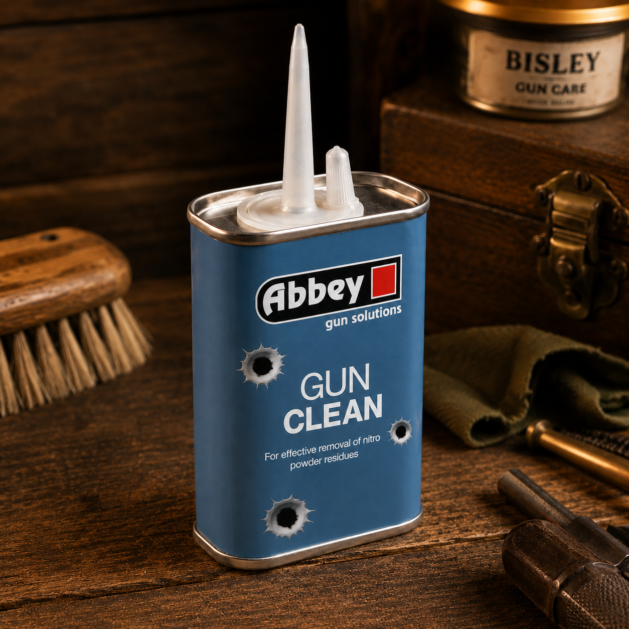 A blue tin of Abbey Gun & rifle Oil with a white cap, designed for cleaning shotguns and rifles in a workshop environment