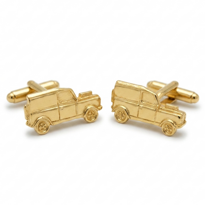 A pair of gold-toned cufflinks shaped like off roaders, displayed on a clean white background.