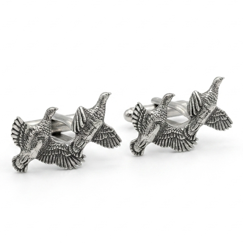 A pair of silver-toned cufflinks shaped like flying partridges with detailed feather and wing textures, photographed on a clean white background.