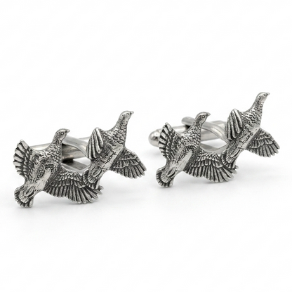 A pair of silver-toned cufflinks shaped like flying partridges with detailed feather and wing textures, photographed on a clean white background.