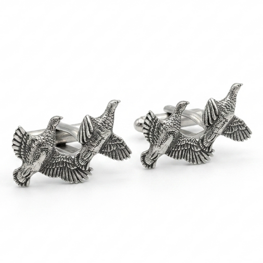 A pair of silver-toned cufflinks shaped like flying partridges with detailed feather and wing textures, photographed on a clean white background.