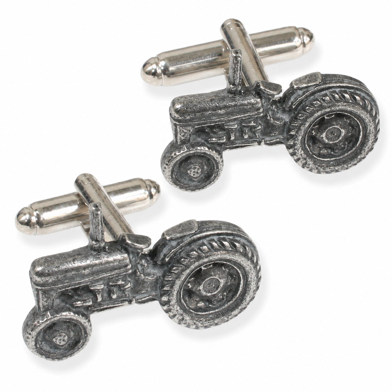 A pair of pewter cufflinks shaped like vintage tractors, shown on a clean white background.