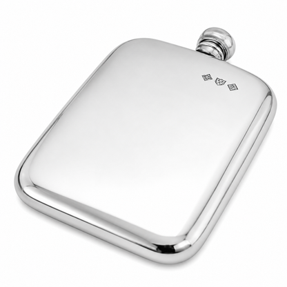 A polished silver metal hip flask with rounded corners and a small engraved monogram near the top, shown on a clean white background.