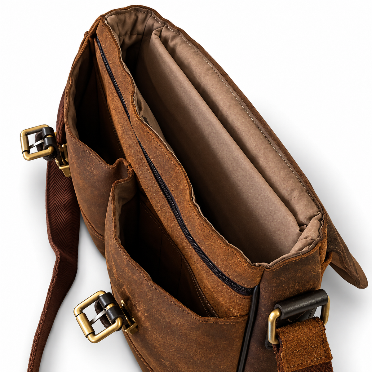 A close-up of a brown leather messenger bag shown open, displaying its interior compartments, padded lining, and brass-tone hardware against a white background.