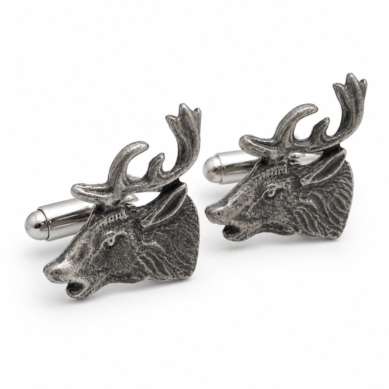 A pair of pewter cufflinks shaped like stag heads with antlers, shown on a clean white background.