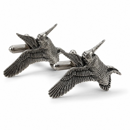 A pair of pewter cufflinks shaped like flying woodcocks with detailed feather textures, shown on a clean white background.